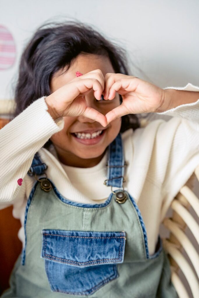 unrecognizable positive hispanic girl making heart gesture during easter celebration